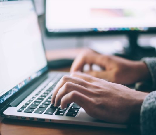 hands typing on a laptop